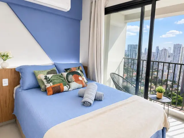 Studio do Hub em Santo Amaro: cama de casal e varanda com vista para a cidade